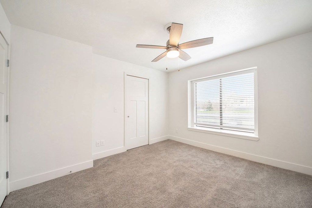 a bedroom with a ceiling fan and a window at Green Ridge Apartments, Grand Rapids, 49544