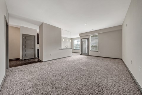 A spacious empty room with carpeted floor and white walls. at River Crossing Apartments, St. Charles, Missouri