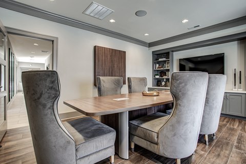 A modern dining room with a wooden table and grey chairs.