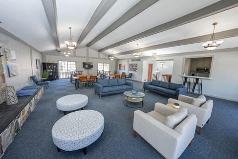 A spacious living room with a stone fireplace and a variety of seating options.