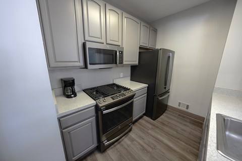 A kitchen with a stove, oven, microwave, and refrigerator.