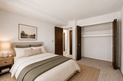 A bedroom with a large bed and a painting on the wall.