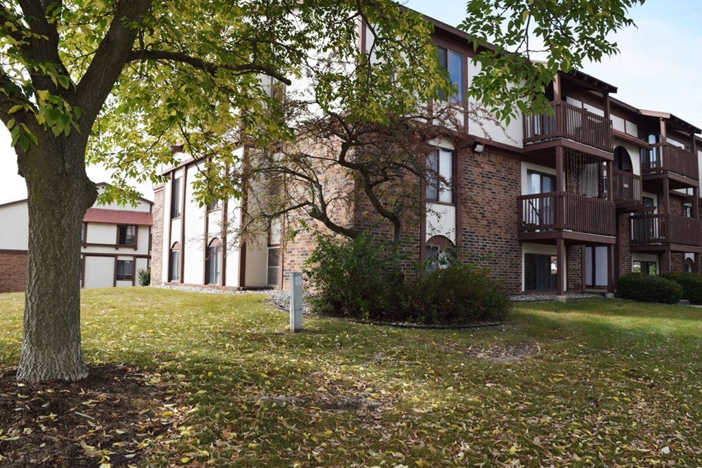 the courtyard of an apartment building with mature shade trees at Seville Apartments, Michigan