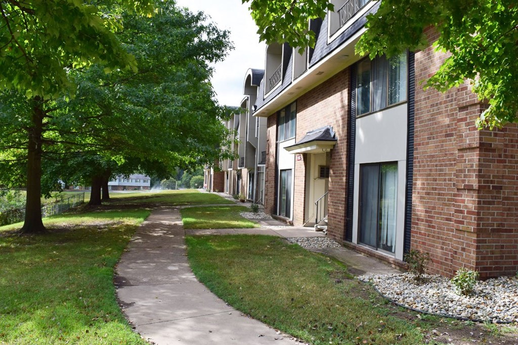 a sidewalk in front of a brick apartment building at Seville Apartments, Michigan