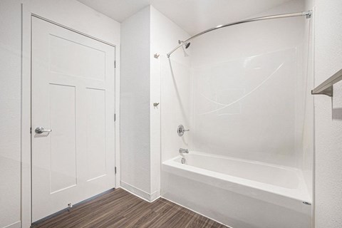 a white bathroom with a shower and a tub  at Signature Pointe Apartment Homes, Alabama
