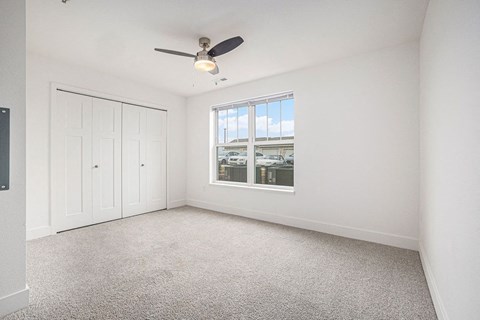 Bedroom with a ceiling fan and a large window  at Signature Pointe Apartment Homes, Athens, AL