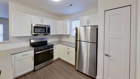 a kitchen with stainless steel appliances and white cabinets
