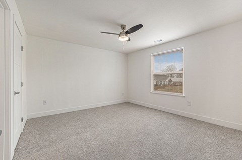 an empty bedroom with a ceiling fan and a window  at Signature Pointe Apartment Homes, Athens, 35611