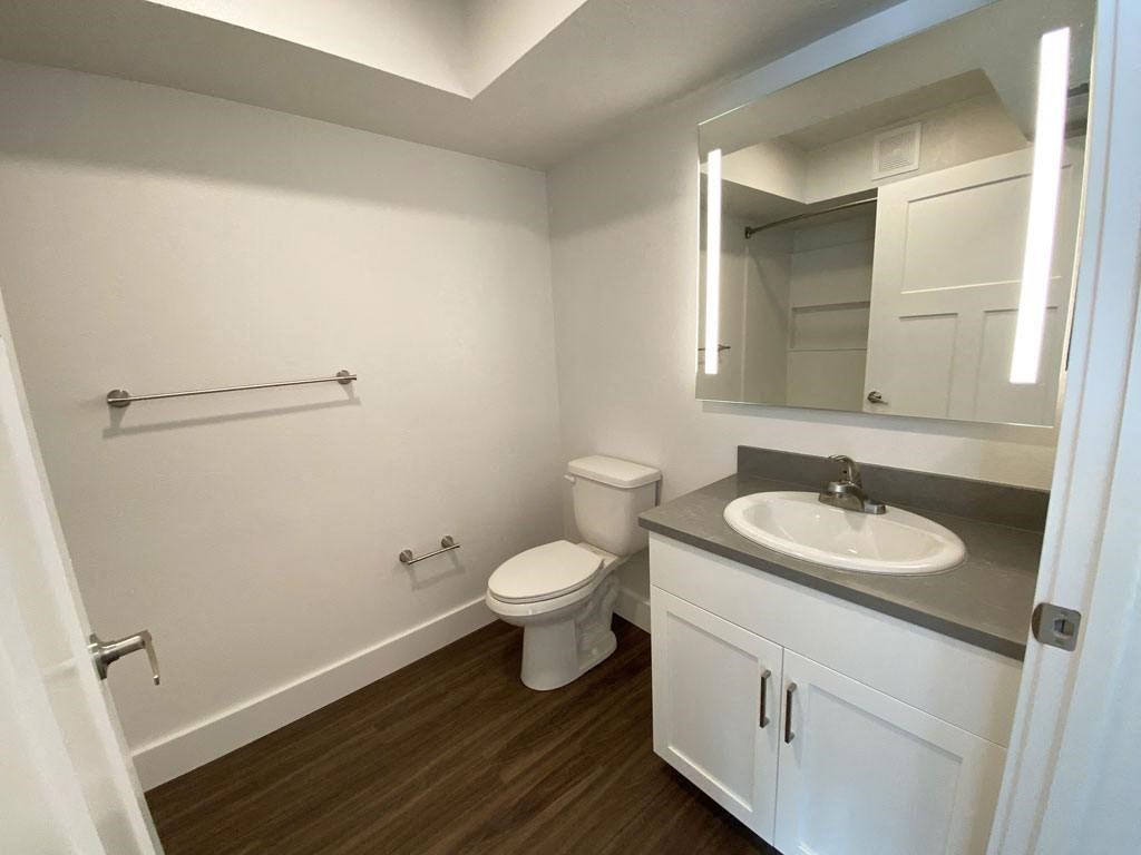 a bathroom with a white cabinetry and hard surface floors at Stoney Pointe Apartment Homes, Wichita, KS