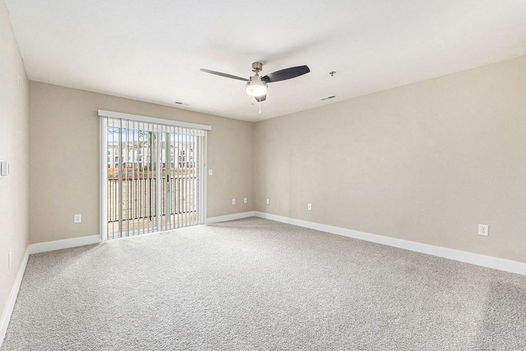 an empty living room with a ceiling fan and a window at Stoney Pointe Apartment Homes, Wichita, 67226