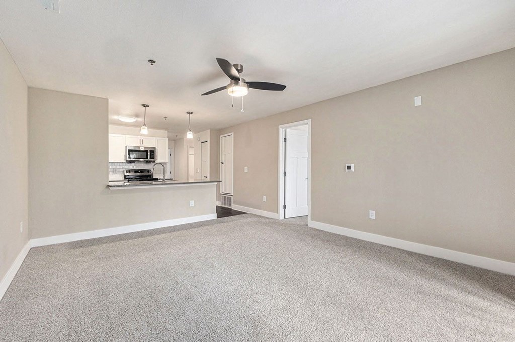 living room facing towards the kitchen with a ceiling fan at Stoney Pointe Apartment Homes, Kansas