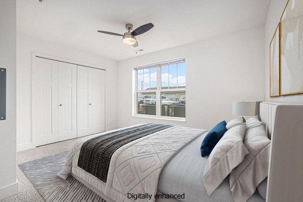 a white bedroom with a large bed and a ceiling fan at Stoney Pointe Apartment Homes, Wichita, KS