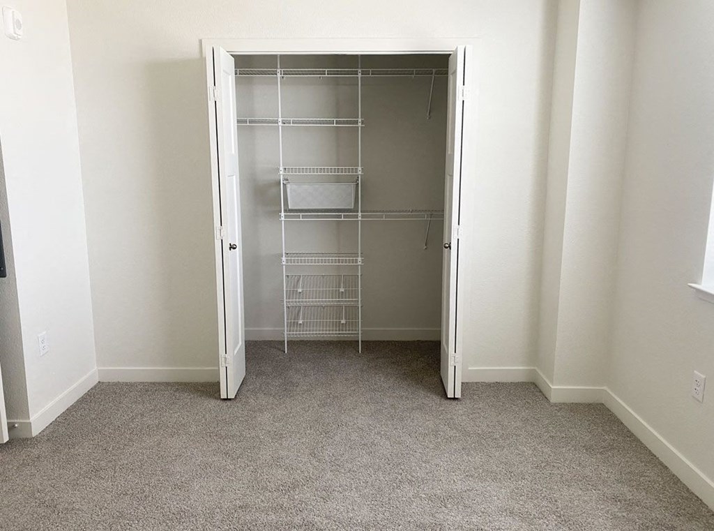 an empty walk in closet in a bedroom with carpeting at Stoney Pointe Apartment Homes, Wichita, KS