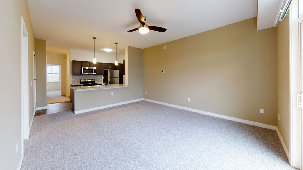 spacious living room with a ceiling fan and a kitchen at Strathmore Apartment Homes, West Des Moines, 50266