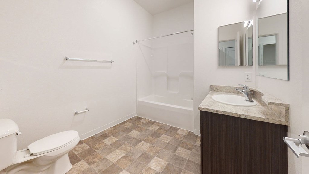 a bathroom with a toilet and a sink and a shower at Strathmore Apartment Homes, West Des Moines, 50266