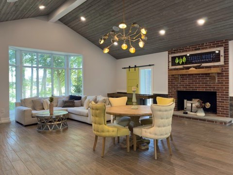 A living room with a fireplace and a dining table with chairs.