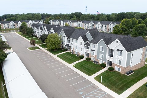 A parking lot in front of apartment buildings.