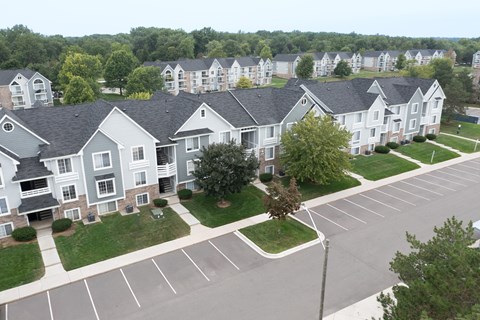 Apartment complex with a parking lot in front.