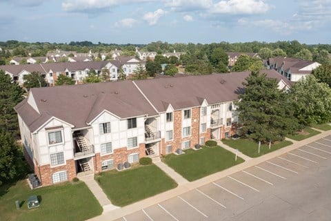 A large apartment complex with a parking lot in front.