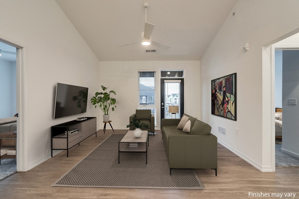 a living room with a couch and a coffee table in front of a tv  at Uptown Square Apartments, Troy