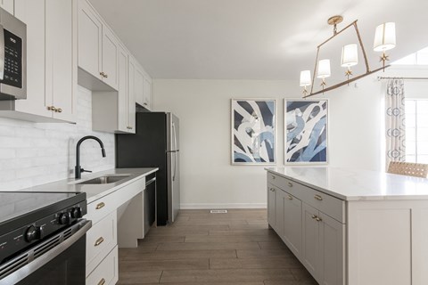A kitchen with white cabinets and a black stove top oven. at Sundance Apartments, Indianapolis, IN