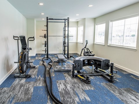 A home gym with a variety of equipment including a treadmill, rowing machine, and weights. at Sundance Apartments, Indiana, 46237
