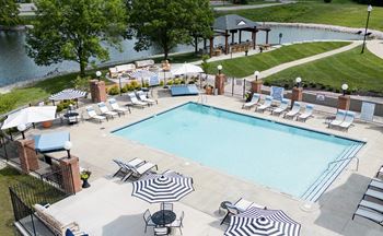A large outdoor swimming pool surrounded by lounge chairs and umbrellas