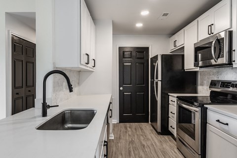 A modern kitchen with black and white appliances and cabinets. at Sundance Apartments, Indianapolis, 46237