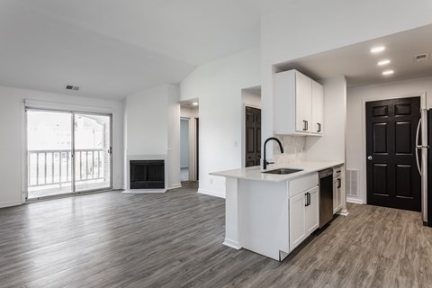 A spacious kitchen with white cabinets and a black door. at Sundance Apartments, Indianapolis, IN