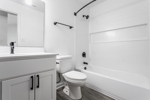 A white bathroom with a toilet, sink, and bathtub. at Sundance Apartments, Indianapolis
