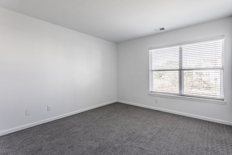 A room with a window and a carpeted floor. at Sundance Apartments, Indianapolis