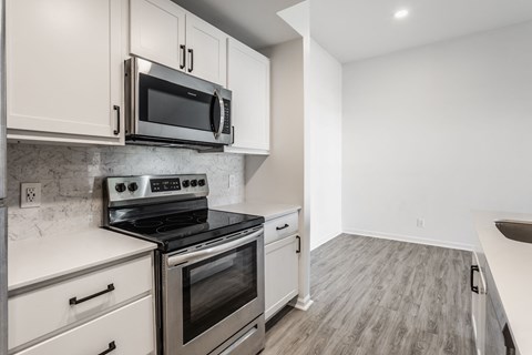A kitchen with a stove top oven and microwave above it. at Sundance Apartments, Indianapolis, Indiana