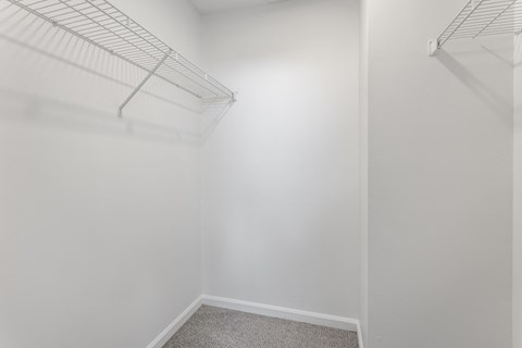 A white closet with a carpeted floor and two metal racks. at Sundance Apartments, Indianapolis, IN