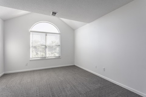 A room with a large window and carpeted floor. at Sundance Apartments, Indianapolis, IN
