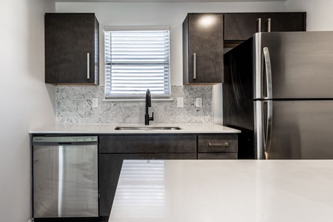 A modern kitchen with a stainless steel refrigerator and a marble backsplash. at Sundance Apartments, Indianapolis, IN, 46237