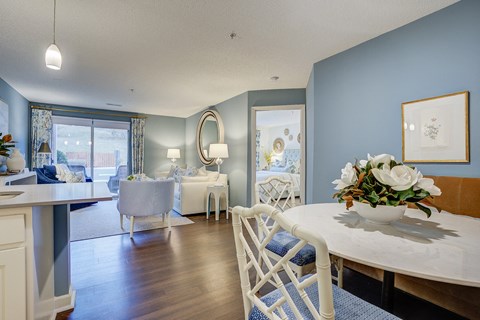 a dining room and living room with blue walls and a white table and chairs