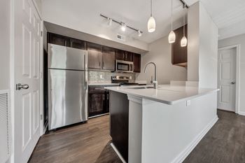 A modern kitchen with a refrigerator, microwave, and oven. at Sunscape Apartments, Roanoke