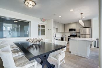 A modern kitchen with a dining table and chairs. at Sunscape Apartments, Roanoke, VA, 24018
