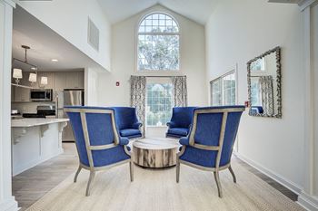 A living room with a blue chair and a coffee table. at Sunscape Apartments, Virginia, 24018