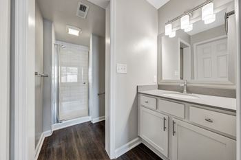 A bathroom with a sink, mirror, and a shower with a glass door. at Sunscape Apartments, Roanoke, 24018