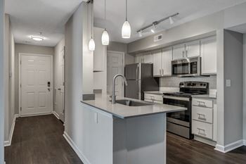 A modern kitchen with a large island and stainless steel appliances. at Sunscape Apartments, Roanoke