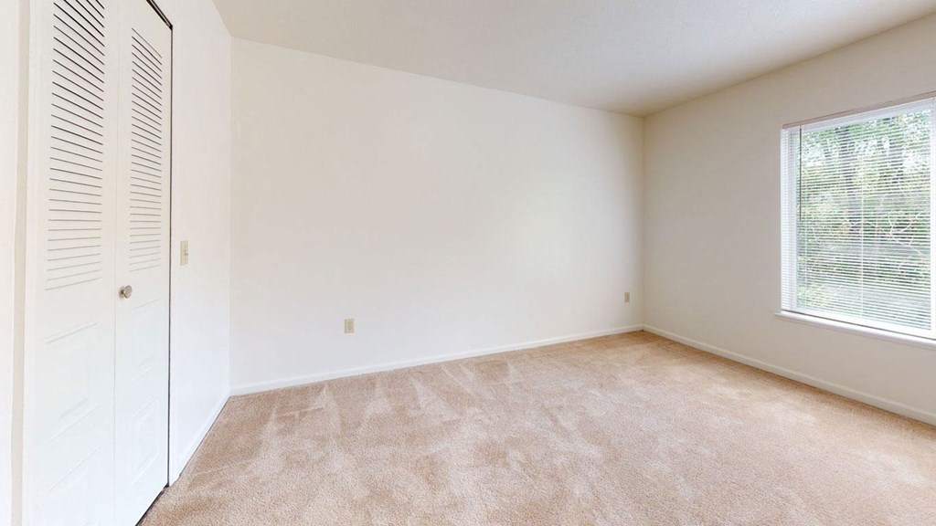 an empty bedroom with a closet and a window at Tall Oaks Apartment Homes, Kalamazoo, 49009