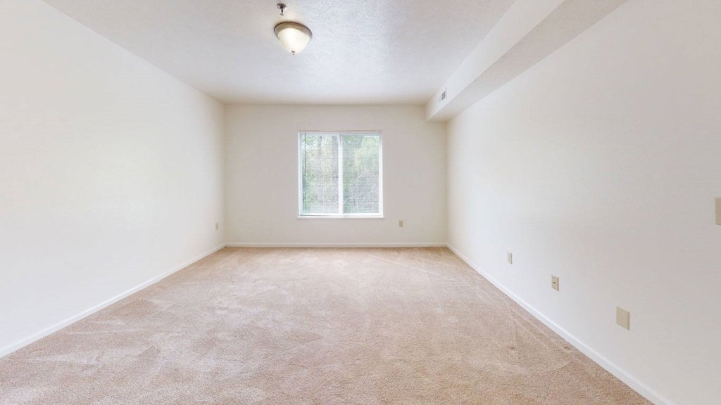 a large, empty bedroom with a window at Tall Oaks Apartment Homes, Kalamazoo, 49009