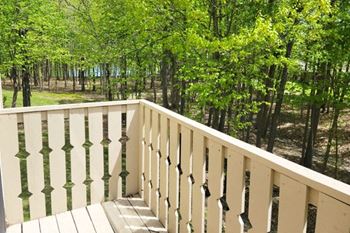 a balcony with a view of a forest at Tanglewood Apartments, Oak Creek, 53154
