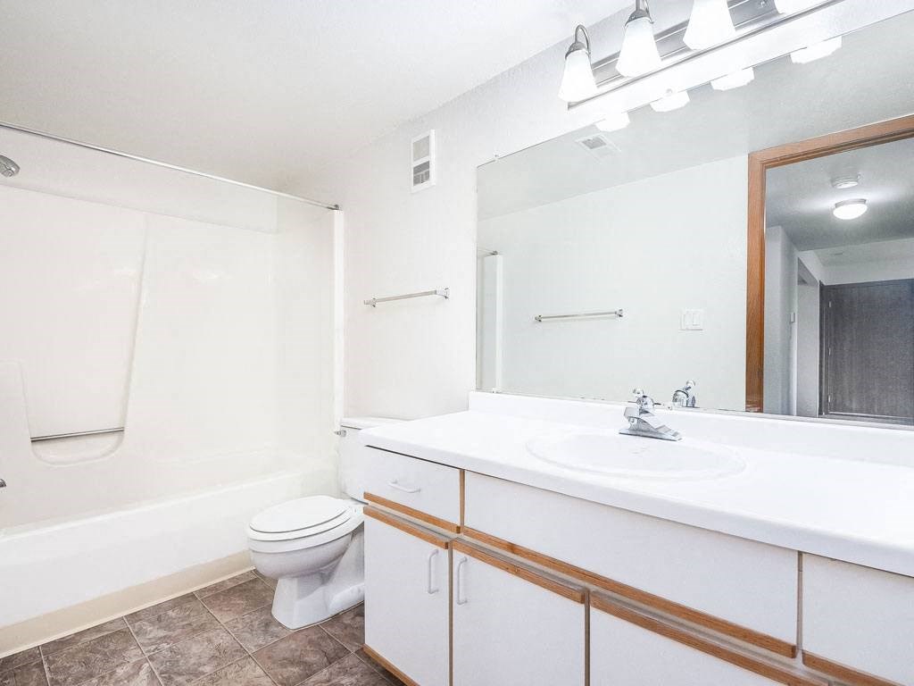 a bathroom with a sink toilet and a mirror at Tanglewood Apartments, Oak Creek, Wisconsin