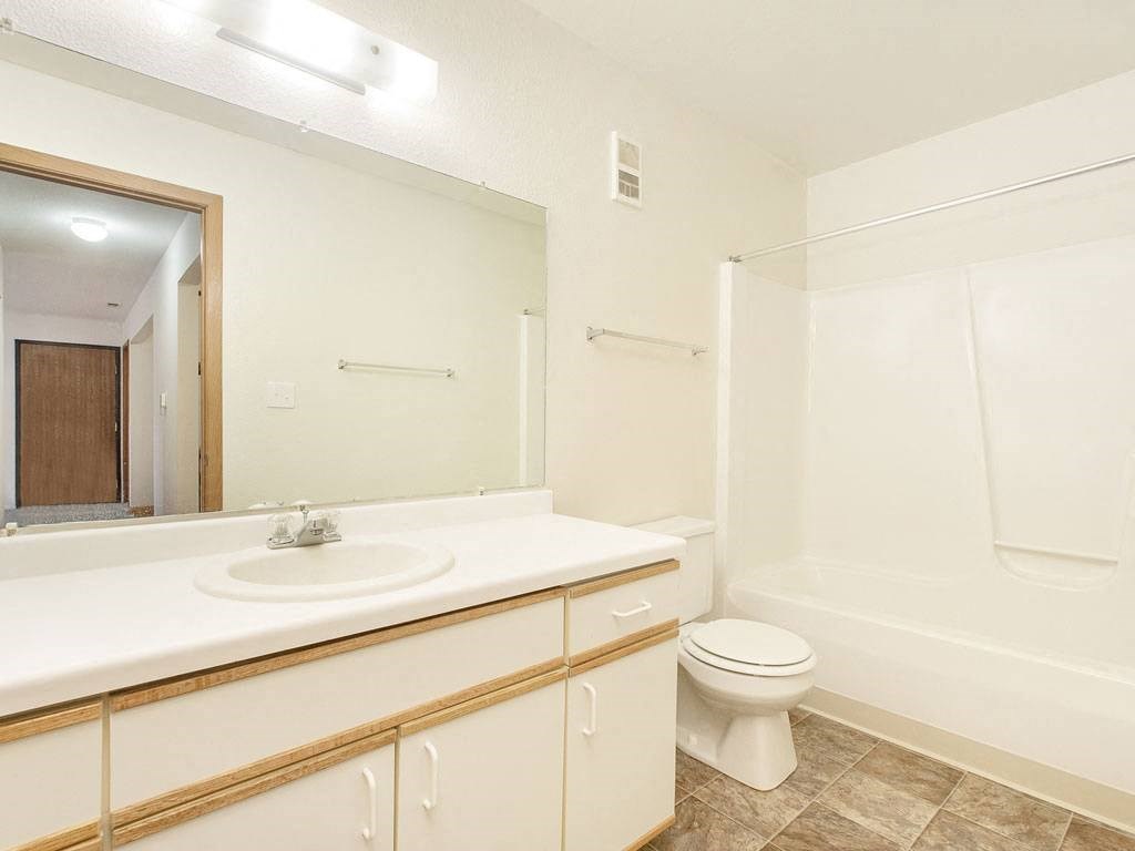 a bathroom with a sink toilet and a mirror at Tanglewood Apartments, Oak Creek, 53154
