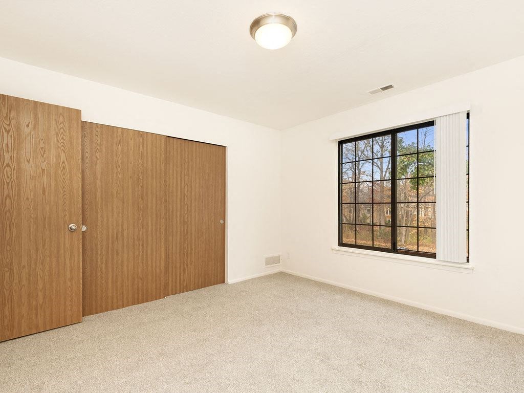 an empty bedroom with a window and a door at Tanglewood Apartments, Oak Creek