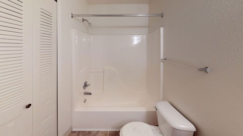 a bathroom with a toilet and a tub and a shower  at Tracy Creek Apartment Homes, Perrysburg, Ohio