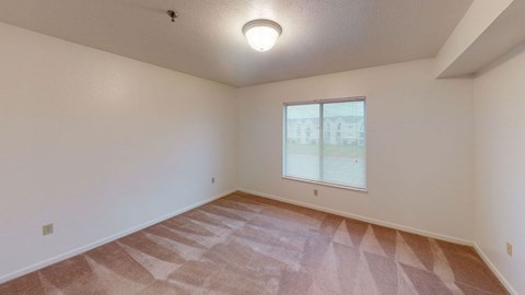 second bedroom with a large window and plush carpeting  at Tracy Creek Apartment Homes, Ohio