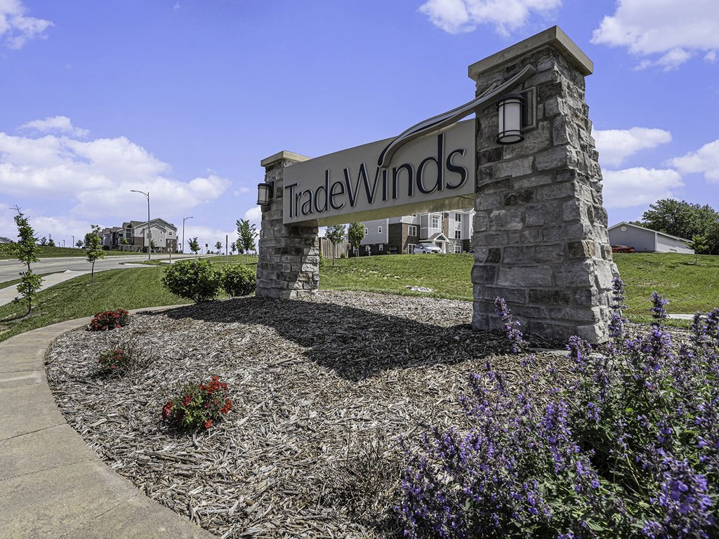 entrance sign with landscaped flowers at Trade Winds Apartment Homes in Elkhorn, NE 68022